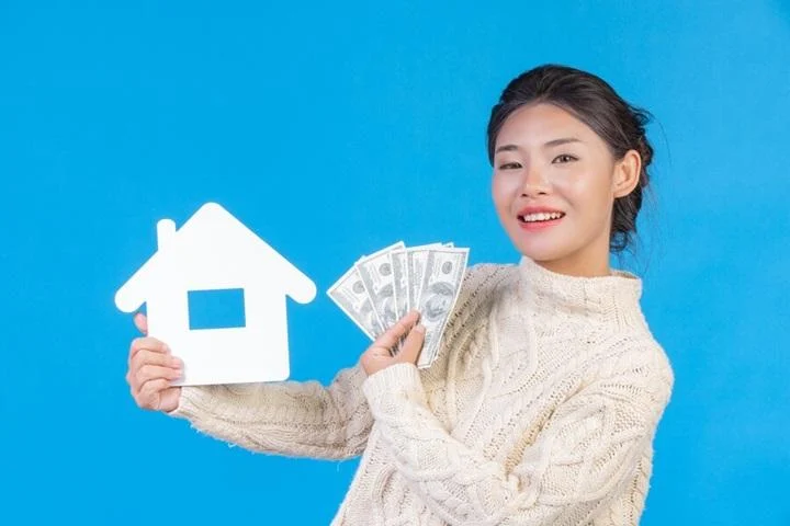 beautiful woman wearing new long sleeved white carpet that holds house symbol dollar bills blue trading 1150 19110